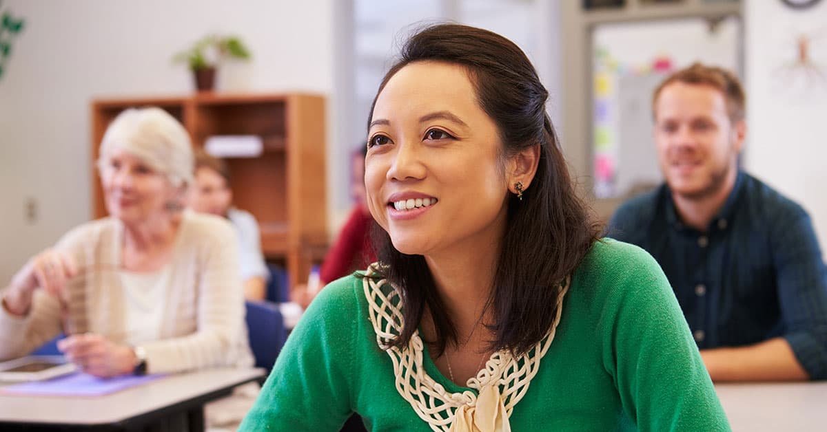 Adult education - woman in green smiling in classroom