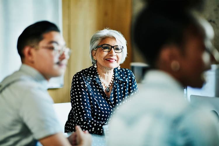 Smiling white-haired Latinx woman in a meeting Smiling white-haired Latinx woman in a meeting