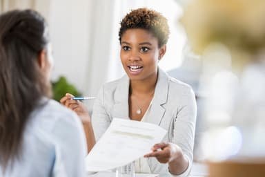 Two women discussing paperwork